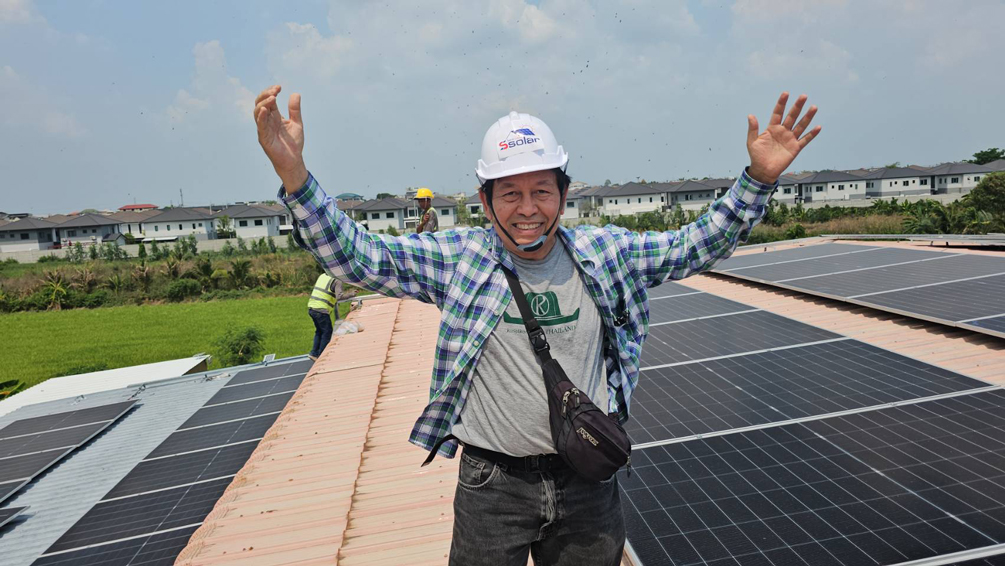 "ทดสอบร่างกายกันหน่อยครับ! เที่ยงวันพอดี ลุงพรขอปีนบันไดขึ้นไปดูระบบโซล่าเซลล์บนหลังคาโรงงานพิมพ์ด้วยตัวเอง ร้อนเอาเรื่องครับ แต่ถ้ามันช่วยลดค่าไฟได้หลักหมื่นต่อเดือน ความร้อนนี้ก็กลายเป็นความคุ้มค่าครับ" (ลุงพร เกษตรก้าวไกล)